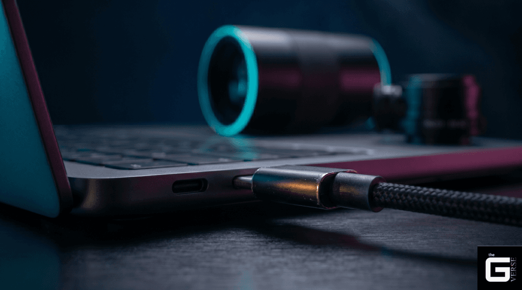 USB-C cable plugged into a laptop with a webcam blurred in the background